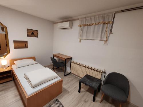 Un dormitorio con una cama, un escritorio y una silla. en Savski Gaj, en Zagreb
