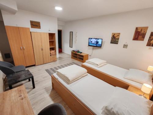 Una habitación con dos camas y una silla y un televisor. en Savski Gaj, en Zagreb