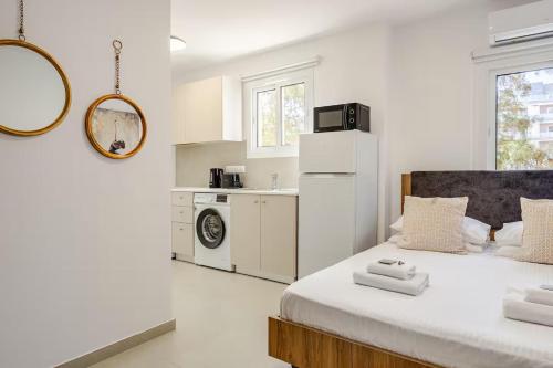a white room with a bed and a kitchen at Urban Bay Studios in Limassol