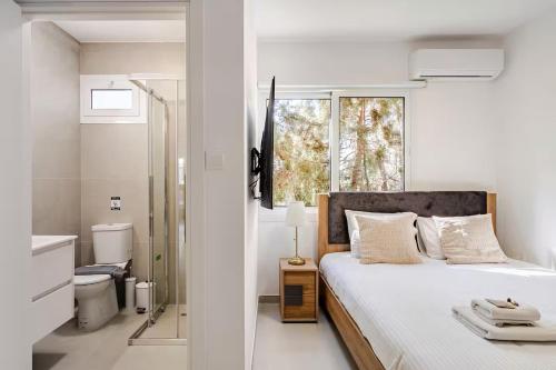 a white bedroom with a bed and a bathroom at Urban Bay Studios in Limassol