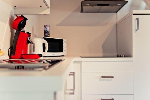 a white kitchen with a stove and a microwave at Appart-Hotel Léopold Liège Centre in Liège