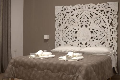 una camera da letto con un grande letto bianco con asciugamani sopra di Terrazza Real Poggio a Napoli