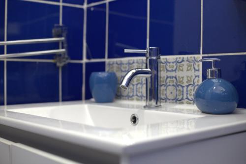 un lavandino in bagno con due vasi blu sopra di Terrazza Real Poggio a Napoli