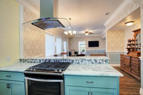 休斯顿Sara's Inn on the Boulevard的厨房配有蓝色橱柜和炉灶烤箱。