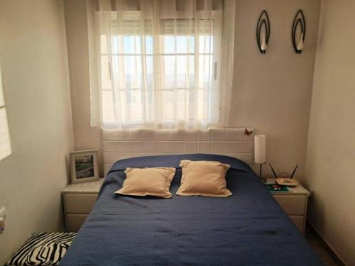 een slaapkamer met een blauw bed met 2 kussens bij Superb Location! in Plettenbergbaai