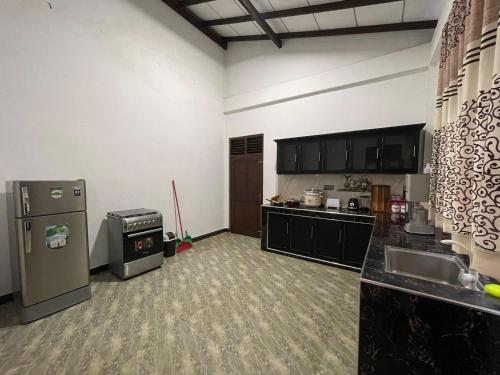 an empty kitchen with a refrigerator and a sink at Ivy Villa - Tangalle in Tangalle