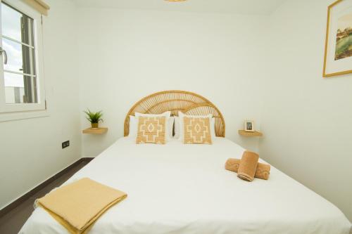una camera da letto con un grande letto bianco con cuscini di Casa Victoria - By AZ Rentals a Playa Honda
