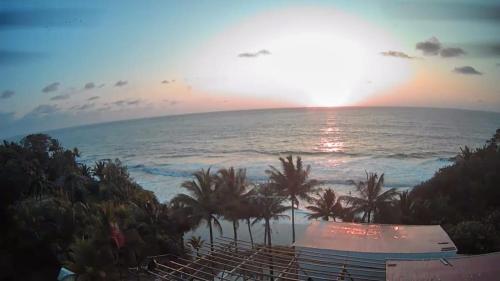 a view of the ocean at sunset from a resort at Hostal Oasis Day in Buenaventura