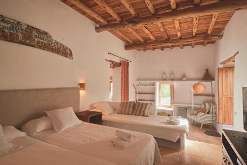 a bedroom with two beds and a living room at Ibiza Holliday Villa Harmony in Sant Jordi