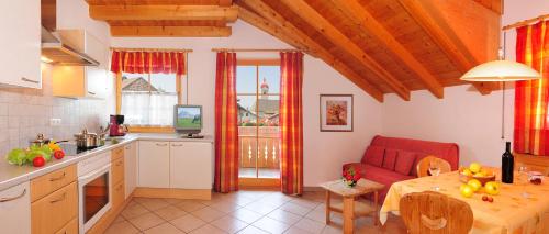 a kitchen and living room with a red couch and a table at Apartment Walder in Fiumes