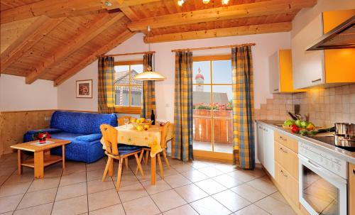 a kitchen and living room with a blue couch and a table at Apartment Walder in Fiumes
