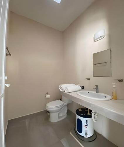 a white bathroom with a toilet and a sink at Villa del Mar, un espacio funcional y bien ubicado in Progreso