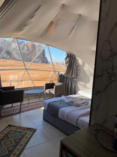 a bedroom with a bed and a large window at Martian landscape camp in Wadi Rum