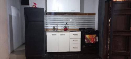 a kitchen with a sink and a refrigerator at Cabaña HEROES in Villa Los Aromos