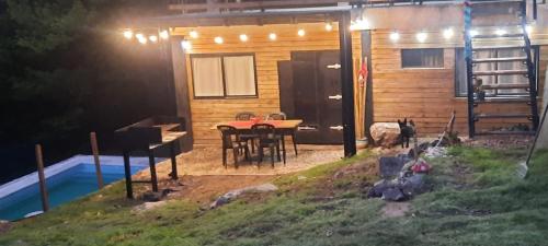 a small cabin with a table and chairs in front of it at Cabaña HEROES in Villa Los Aromos