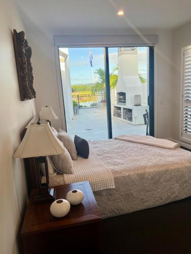 a bedroom with a bed with a view of a patio at The Waterways Boathouse in Whitianga
