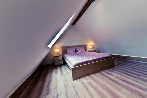 a bedroom with a bed with a purple comforter at Appart-Hotel Léopold Liège Centre in Liège