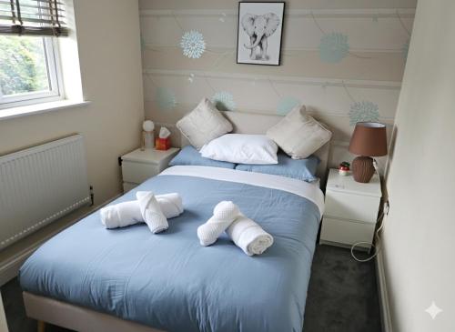 a bedroom with a bed with towels on it at Spacious Modern 5 bedroom home near Heathrow Windsor in Canvey