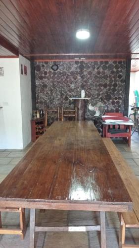 a large wooden table in a room with a stone wall at La Soñada in San Miguel del Monte