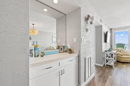 ein weißes Badezimmer mit Waschbecken und Spiegel in der Unterkunft Atlantic Dunes Resort Unit 502 with Direct Oceanfront Balcony in Myrtle Beach