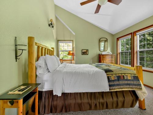 Un dormitorio con cama, escritorio y ventanas en Moose Manor, en Zigzag