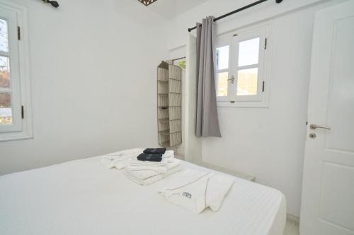 Diamantis Kitesurf Residencies في ميكري فيغلا: غرفة بيضاء بها سرير ونافذة