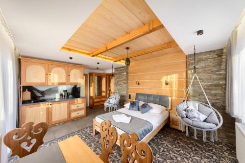 Un dormitorio con una cama y un columpio. en Modrzewiowa Apartamenty, en Poronin