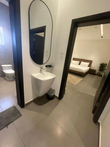 a bathroom with a sink and a mirror at Najd APARTMENTS in Al-ʿUla
