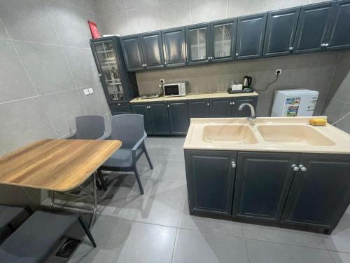 a kitchen with a sink and a table with chairs at Najd Hotel in AlUla