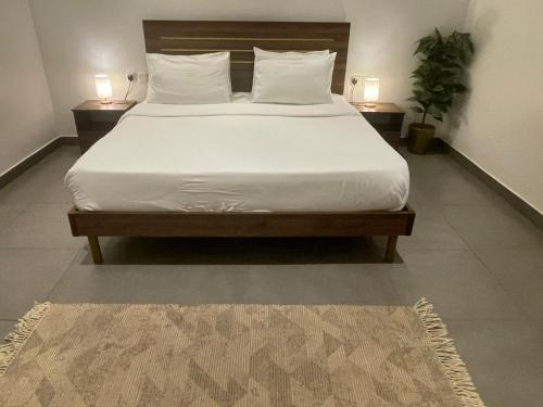 a bed with white sheets and pillows on it in a bedroom at Najd Hotel in AlUla