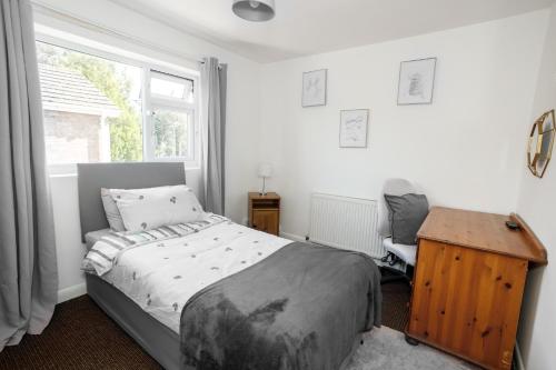 ein Schlafzimmer mit Bett, Schreibtisch und Fenster in der Unterkunft Home from Home in Leicester