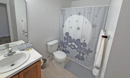a bathroom with a toilet and a shower curtain at Paradise Cay Resort - Near to Disney in Kissimmee