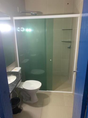 a bathroom with a toilet and a glass shower at pousada Requenguela in Icapuí