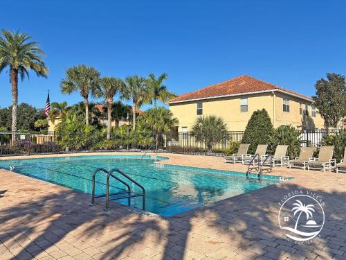 a swimming pool with palm trees and a house at Paradise Cay Resort - Near to Disney in Kissimmee