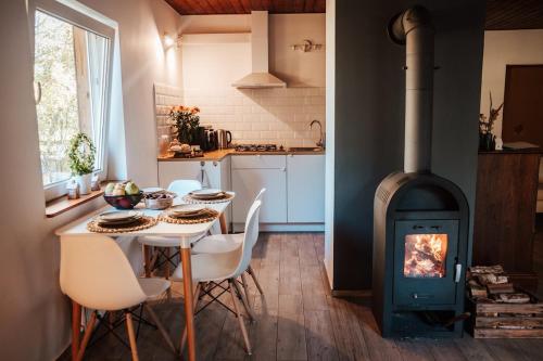 eine Küche mit einem Tisch und einem Holzofen in der Unterkunft Dream house surrounded by silence in Milicz