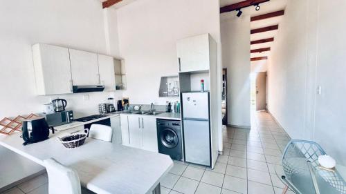 een keuken met witte kasten en een wasmachine en droger bij Fanieta Lagoon in Vosburg