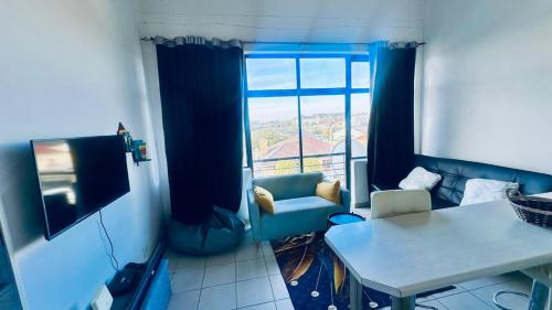 een woonkamer met een bank, een tafel en een raam bij Fanieta Lagoon in Vosburg