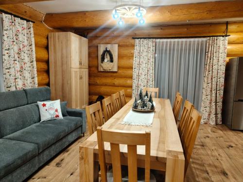 a dining room with a table and a couch at Apartamenty Drewutnia w Wiśle in Wisła