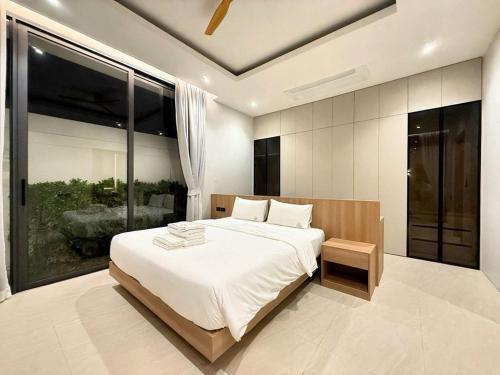 a bedroom with a large bed and a large window at Chalong Brand New 4BR Pool Villa Phuket VVPHU51 in Chalong 