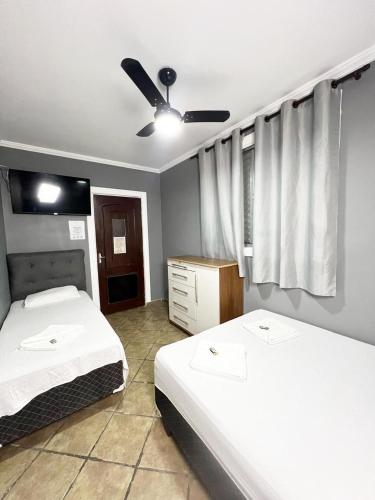 ein Schlafzimmer mit zwei Betten und einem Deckenventilator in der Unterkunft Hostel Anprado #10 in Guarulhos