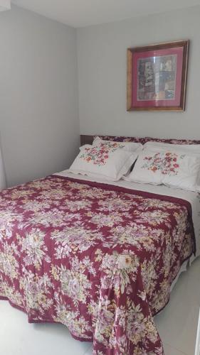 a bedroom with a bed with a red and white blanket at BRISAS DO FAROL casa 208 in Salvador