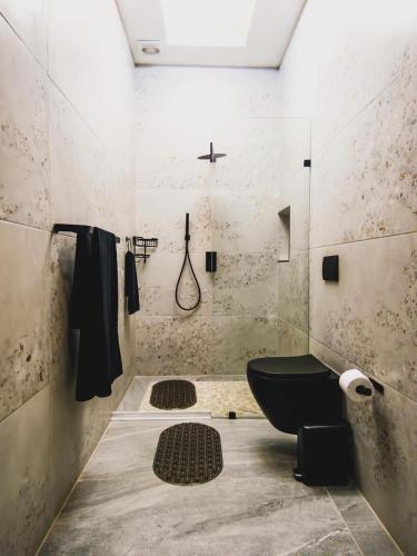 a bathroom with a black toilet and a sink at Hudson Haven Bed & Breakfast in Pietermaritzburg