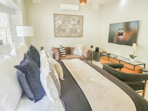 un soggiorno con un letto e un divano di Hudson Haven Bed & Breakfast a Pietermaritzburg