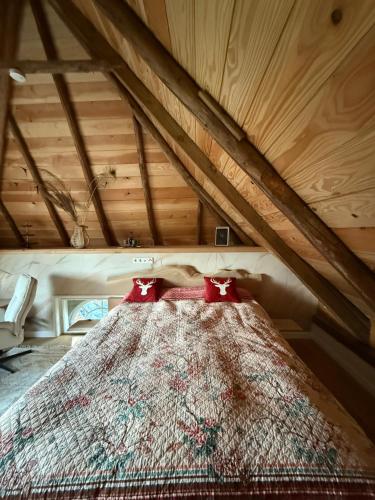 LageNanas Scheune的阁楼里一张铺着红色枕头的床