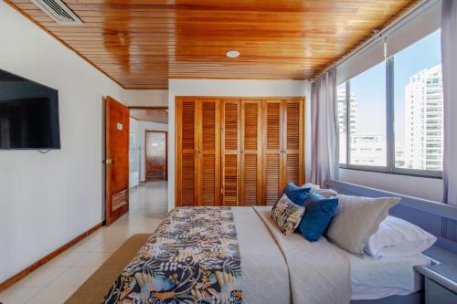 a bedroom with a large bed and a large window at Habitación doble baño privado cerca al mar y bahia in Cartagena de Indias