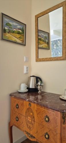 uma cómoda de madeira com um espelho na parede em Slitebadens Annex em Slite