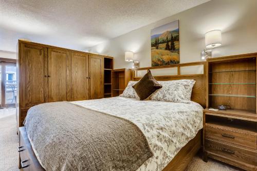 a bedroom with a large bed and wooden cabinets at Lift House Lodge, Remodeled Downtown Lionshead Studio Condo in Vail