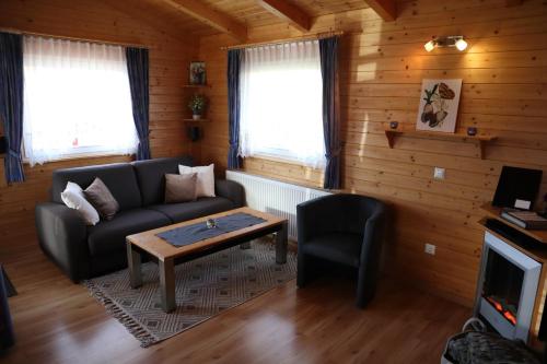 a living room with a couch and a table at Ferienhaus LiRa in Drobollach am Faaker See