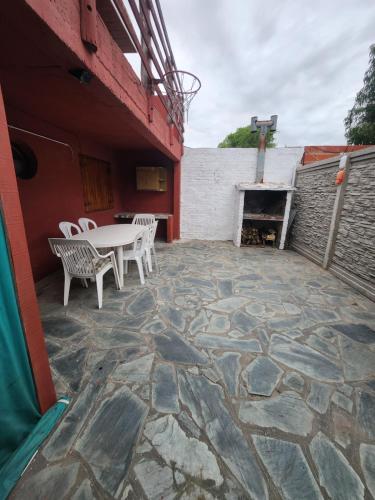 eine Terrasse mit einem Tisch, Stühlen und einem Kamin in der Unterkunft Casa Sta RoCa in Santa Clara del Mar