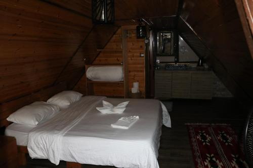 a bedroom with a white bed in a cabin at Dana luxury huts in Dana